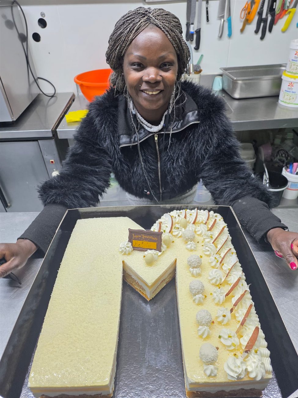 Marie présentant un gâteau lettre lors d'un cours de cuisine à domicile